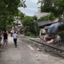 Train in Vietnam runs through car parked along tracks, driver was shopping at nearby market
